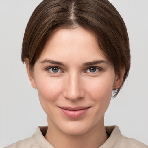 Joyful white young-adult female with short  brown hair and grey eyes