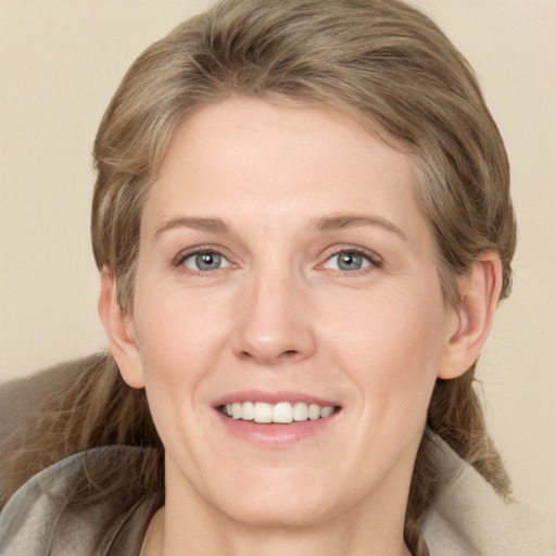 Joyful white young-adult female with medium  brown hair and grey eyes