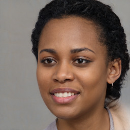 Joyful black young-adult female with long  brown hair and brown eyes