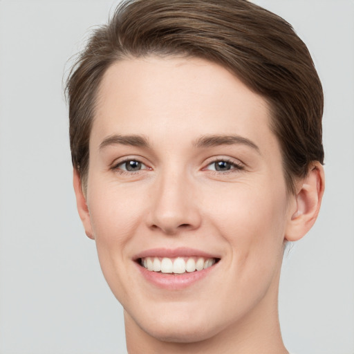 Joyful white young-adult female with short  brown hair and grey eyes