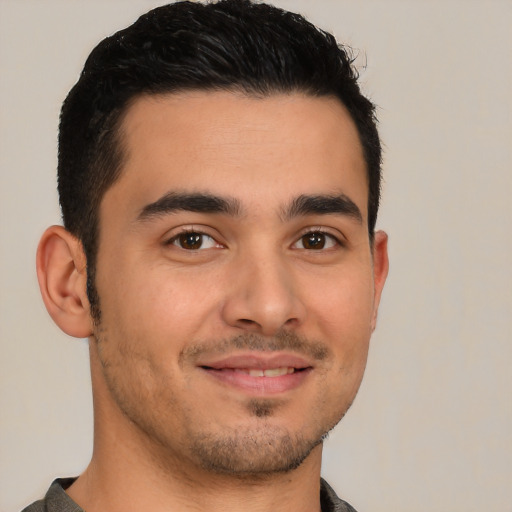 Joyful latino young-adult male with short  brown hair and brown eyes