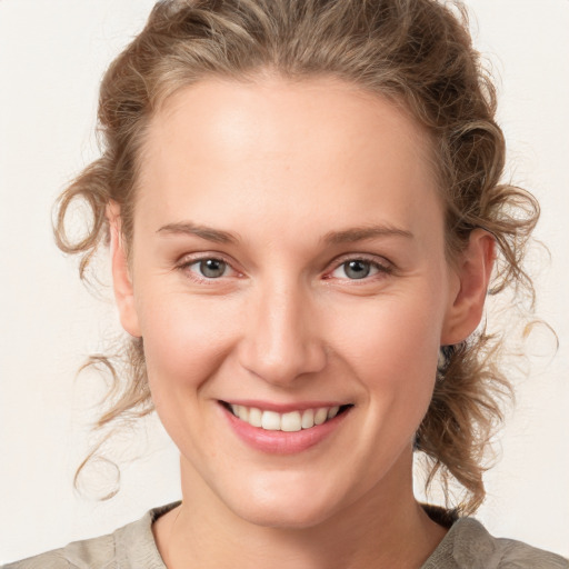 Joyful white young-adult female with medium  brown hair and blue eyes