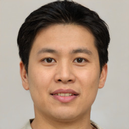 Joyful asian young-adult male with short  brown hair and brown eyes