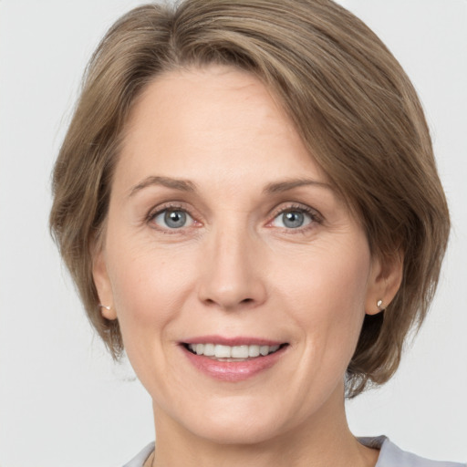 Joyful white adult female with medium  brown hair and grey eyes