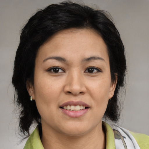 Joyful asian adult female with medium  brown hair and brown eyes