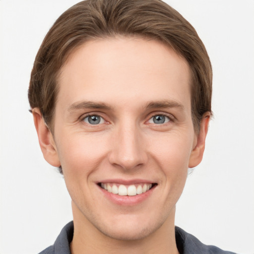 Joyful white young-adult male with short  brown hair and grey eyes