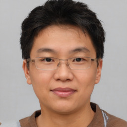 Joyful asian adult male with short  brown hair and brown eyes