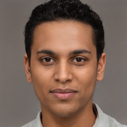 Joyful latino young-adult male with short  black hair and brown eyes