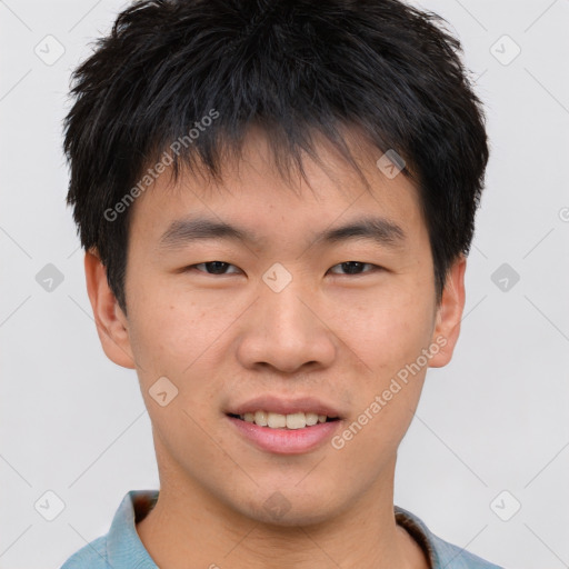 Joyful asian young-adult male with short  brown hair and brown eyes