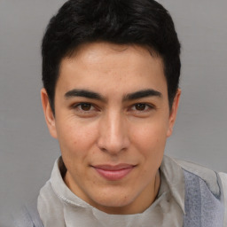 Joyful latino young-adult male with short  brown hair and brown eyes