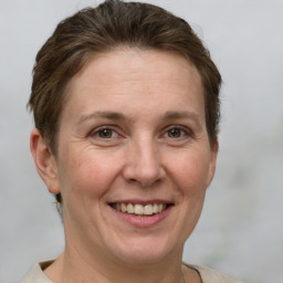 Joyful white adult female with short  brown hair and grey eyes