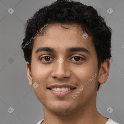 Joyful latino young-adult male with short  brown hair and brown eyes