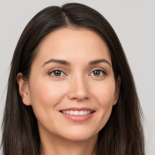 Joyful white young-adult female with long  brown hair and brown eyes