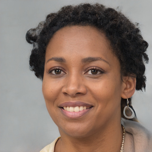 Joyful black young-adult female with short  brown hair and brown eyes