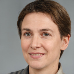 Joyful white adult female with medium  brown hair and grey eyes