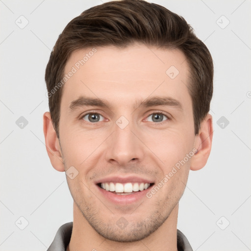 Joyful white young-adult male with short  brown hair and grey eyes