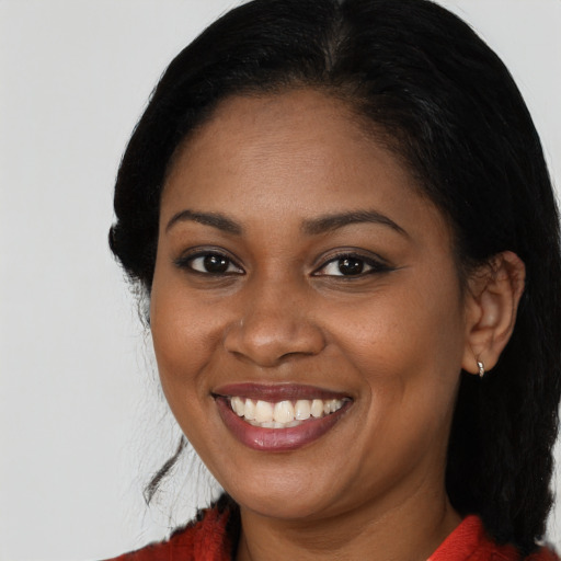 Joyful black young-adult female with long  black hair and brown eyes
