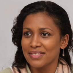 Joyful black young-adult female with long  brown hair and brown eyes