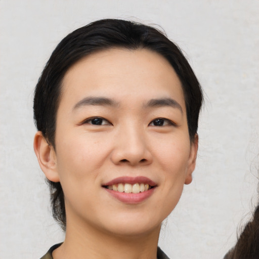 Joyful asian young-adult female with medium  black hair and brown eyes