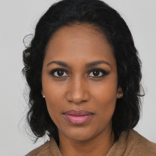 Joyful black young-adult female with long  black hair and brown eyes