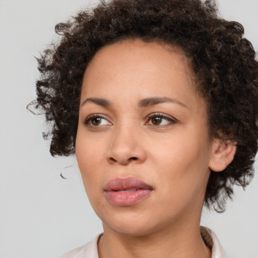 Joyful black young-adult female with medium  brown hair and brown eyes