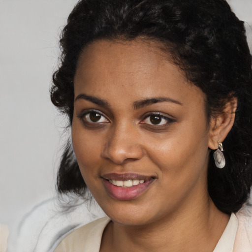 Joyful black young-adult female with long  brown hair and brown eyes