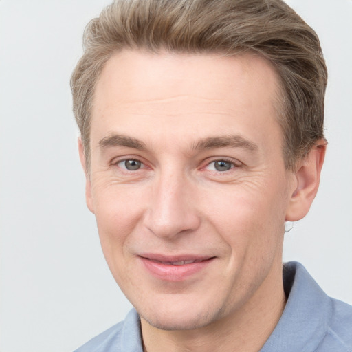 Joyful white adult male with short  brown hair and grey eyes