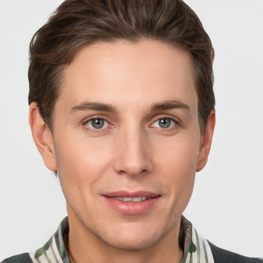 Joyful white young-adult male with short  brown hair and grey eyes