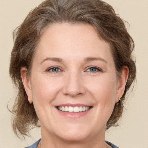 Joyful white adult female with medium  brown hair and grey eyes