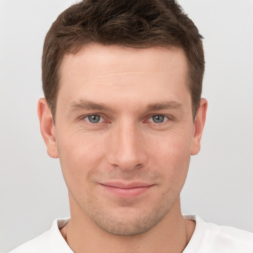 Joyful white young-adult male with short  brown hair and grey eyes