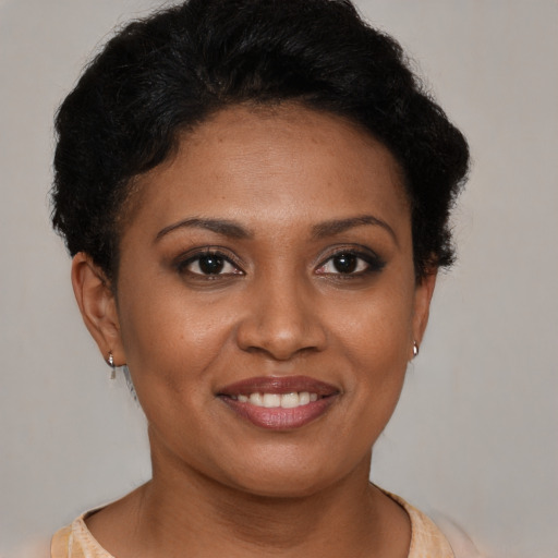 Joyful black young-adult female with short  brown hair and brown eyes