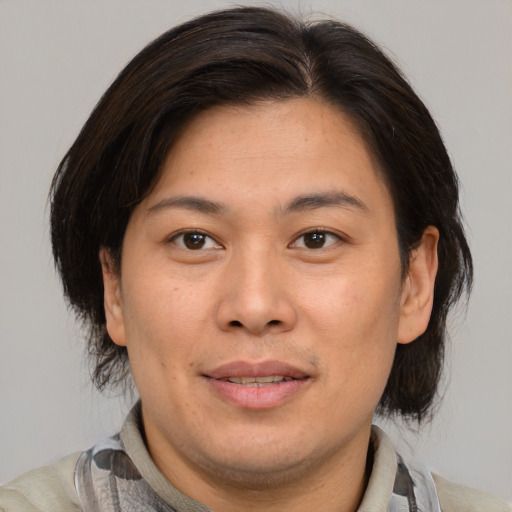 Joyful asian adult female with medium  brown hair and brown eyes