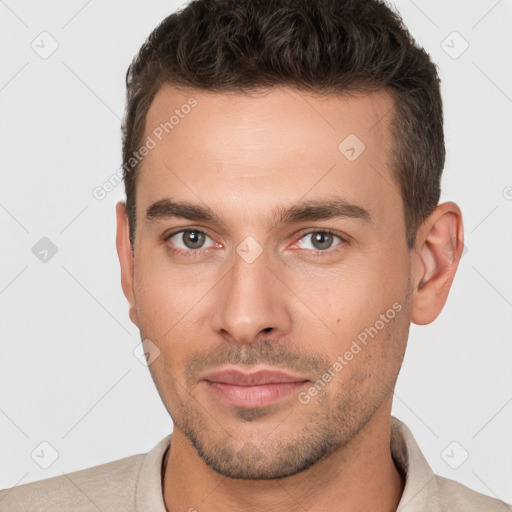 Joyful white young-adult male with short  brown hair and brown eyes