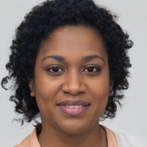 Joyful black young-adult female with long  brown hair and brown eyes