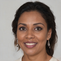 Joyful black adult female with medium  brown hair and brown eyes