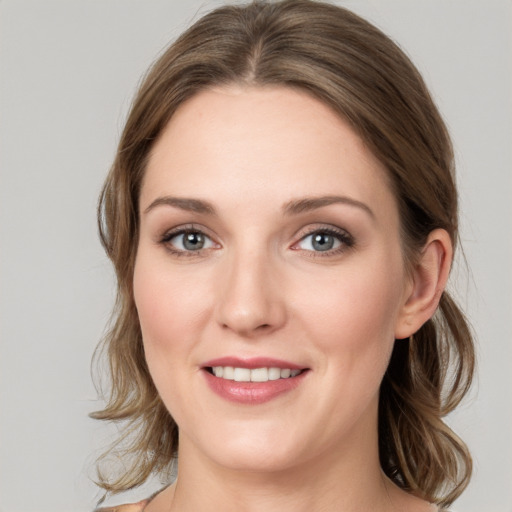 Joyful white young-adult female with medium  brown hair and grey eyes