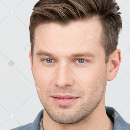 Joyful white young-adult male with short  brown hair and grey eyes