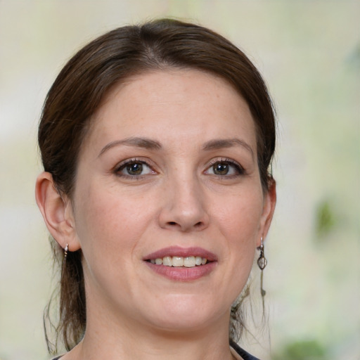 Joyful white adult female with medium  brown hair and green eyes