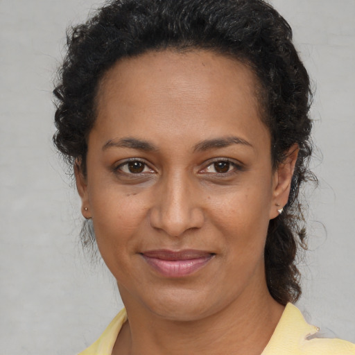 Joyful black young-adult female with medium  brown hair and brown eyes