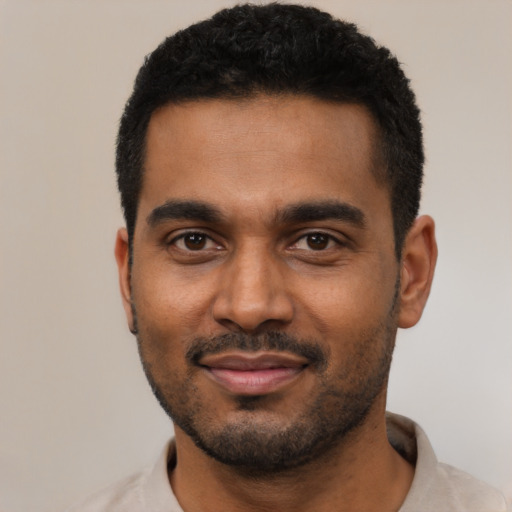 Joyful black young-adult male with short  black hair and brown eyes