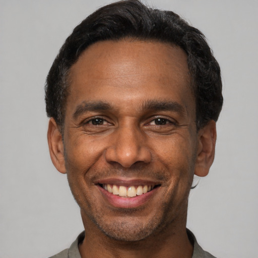Joyful black adult male with short  black hair and brown eyes