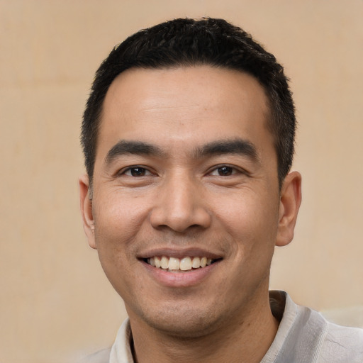 Joyful latino young-adult male with short  black hair and brown eyes