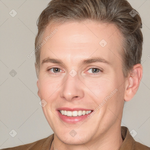 Joyful white adult male with short  brown hair and grey eyes