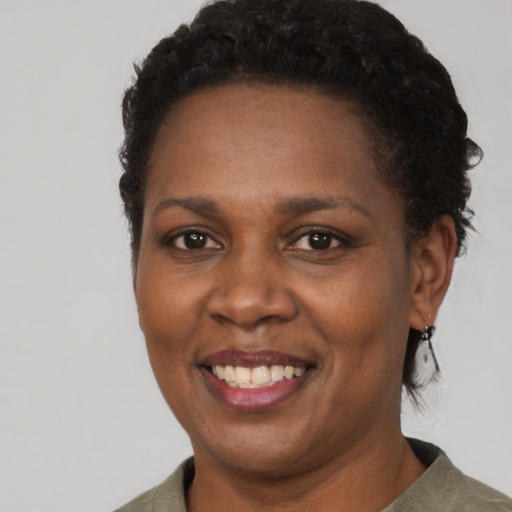 Joyful black adult female with short  black hair and brown eyes