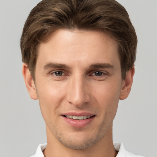 Joyful white young-adult male with short  brown hair and grey eyes