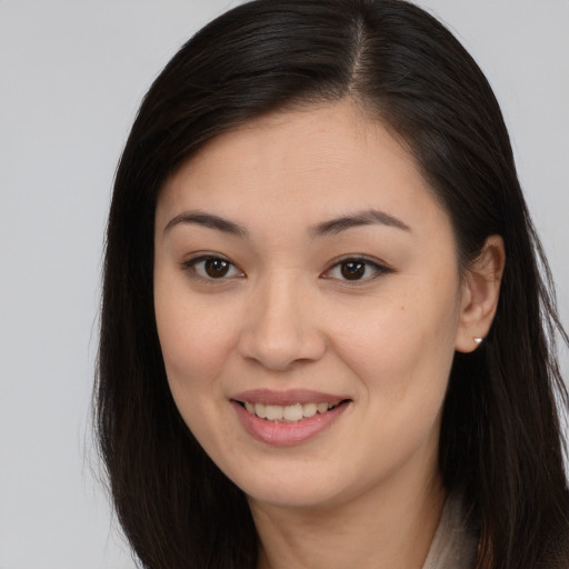 Joyful asian young-adult female with long  brown hair and brown eyes