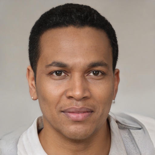 Joyful latino young-adult male with short  brown hair and brown eyes