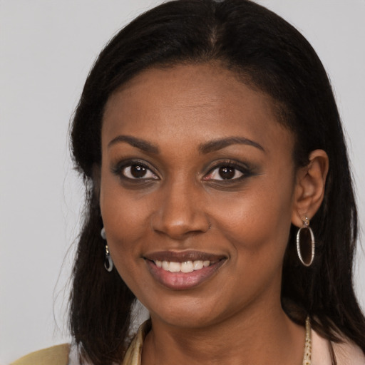 Joyful black young-adult female with long  brown hair and brown eyes