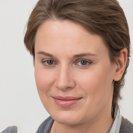 Joyful white young-adult female with medium  brown hair and grey eyes