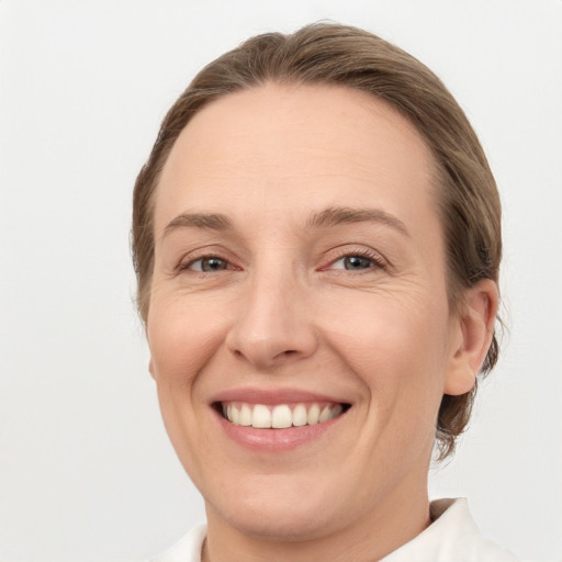 Joyful white adult female with medium  brown hair and grey eyes